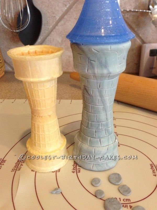 two clay towers sitting on top of a table next to a knife and other items