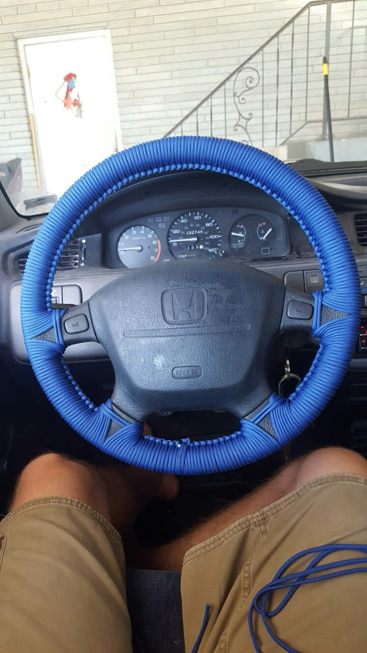 a person sitting in the driver's seat of a car with their feet on the steering wheel