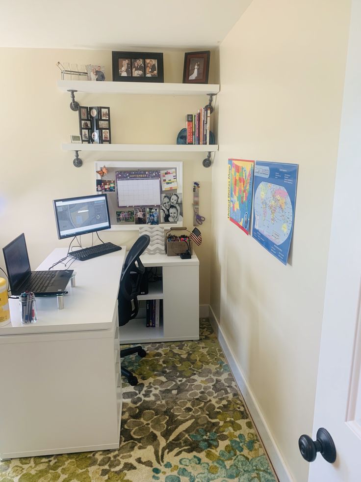 a home office with two computer screens on the desk and a rug in front of it