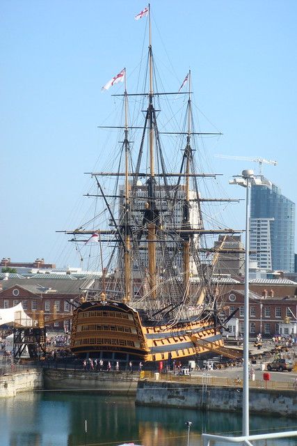 an old sailing ship is docked in the water next to some buildings and other boats