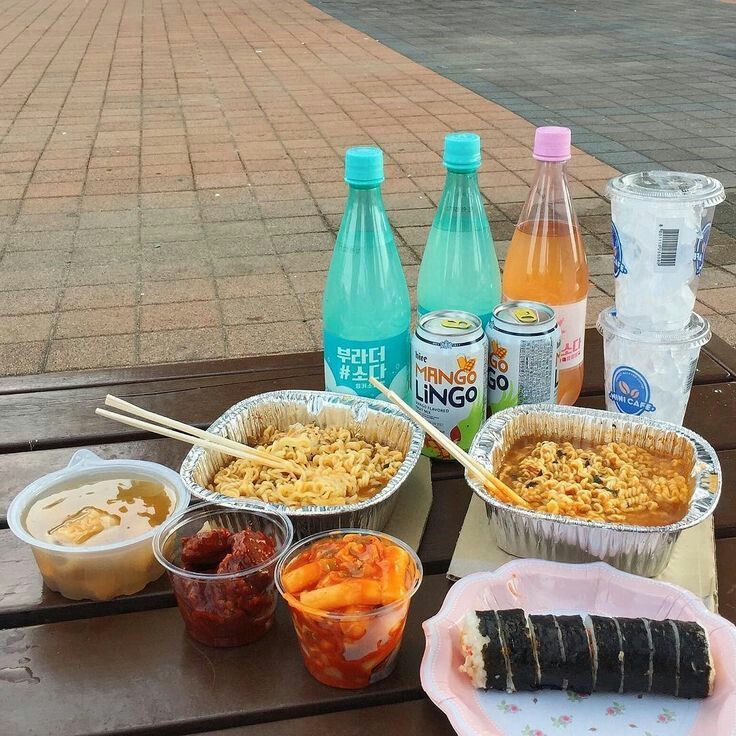 some food is sitting on a picnic table with drinks and water bottles in the background