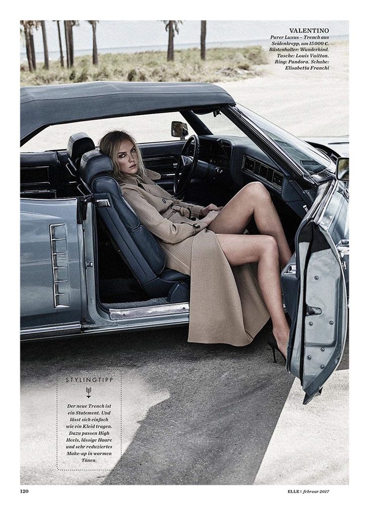 a woman sitting in the driver's seat of a car with her legs crossed