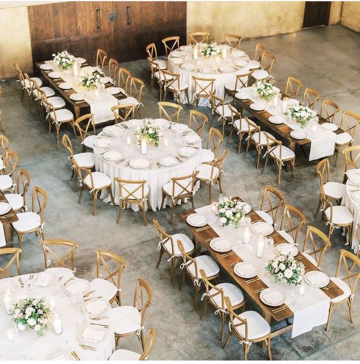 tables and chairs are set up with white linens for an elegant dinner party or function