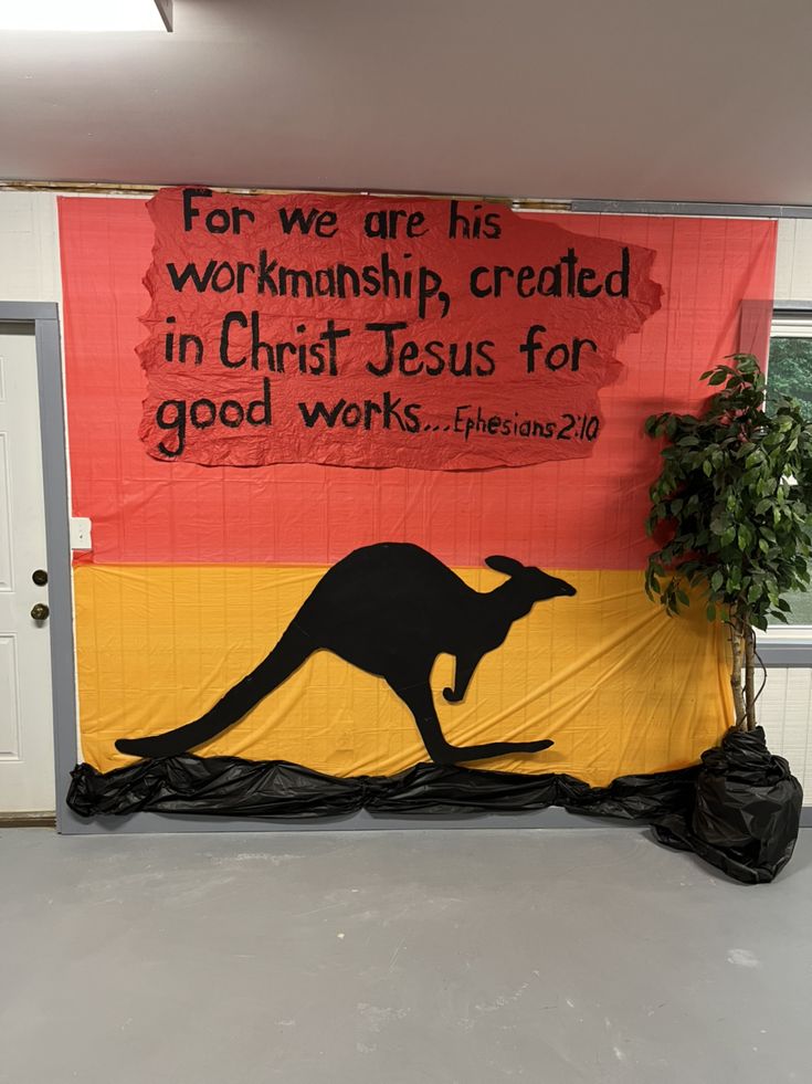 a large sign with a kangaroo on it in front of a door that says for we are his worship created in christ jesus for good works