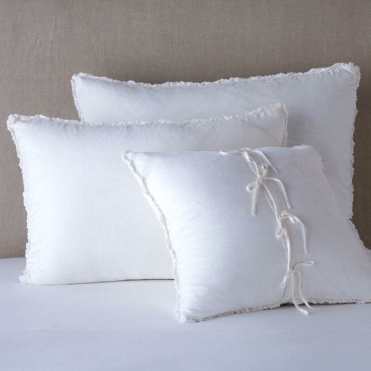 three white pillows on top of a bed