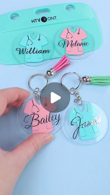 three keychains with name tags attached to them, one being held by a person's hand