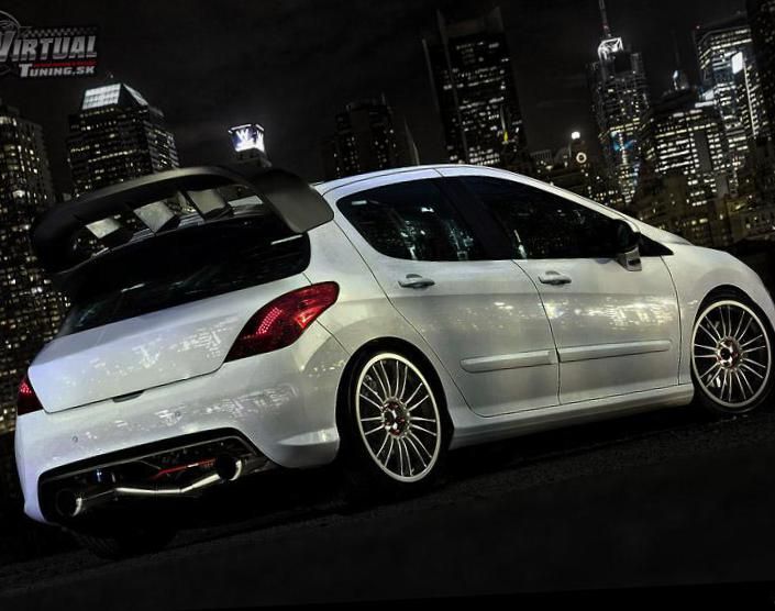 a white car parked in front of a city at night