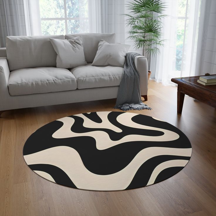 a living room with a white couch and black and white rug on the wooden floor