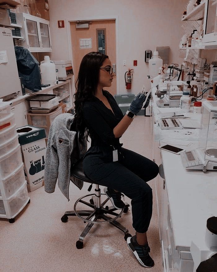 a woman sitting on a chair in a lab