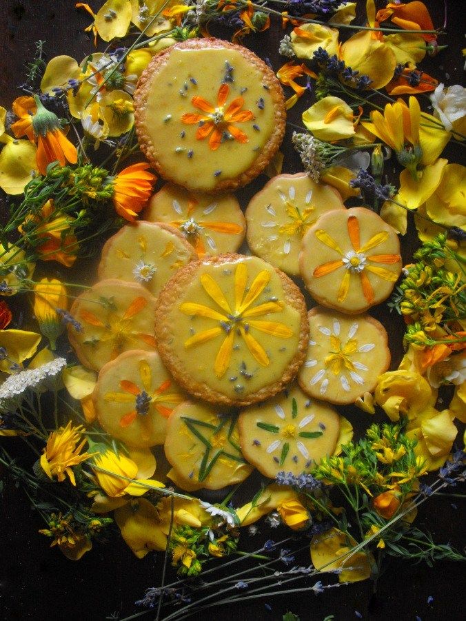 there are some cookies that have been decorated with yellow flowers and daisies on the table