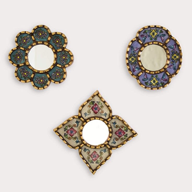 three decorative mirrors are shown on a white surface and one has a circular mirror in the middle