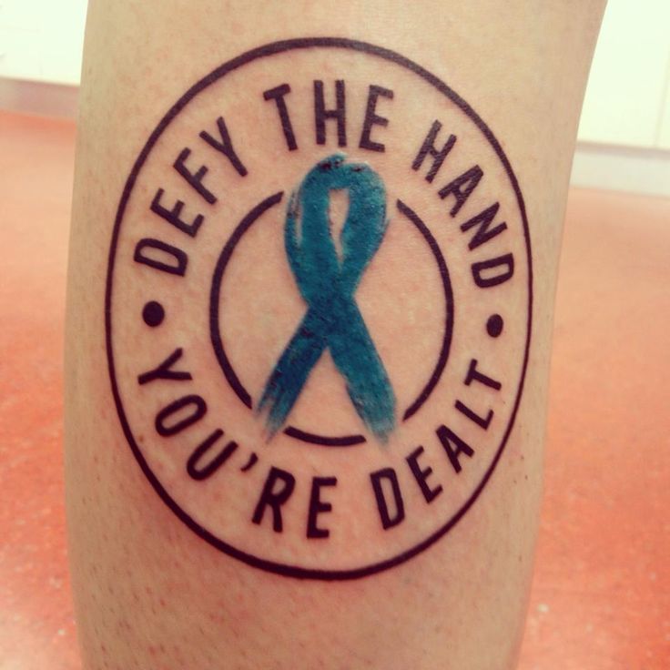 a blue ribbon on the side of a leg that says, defy the hand you're deal