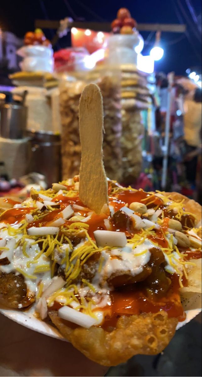 a close up of a pizza with toppings and a wooden stick sticking out of it