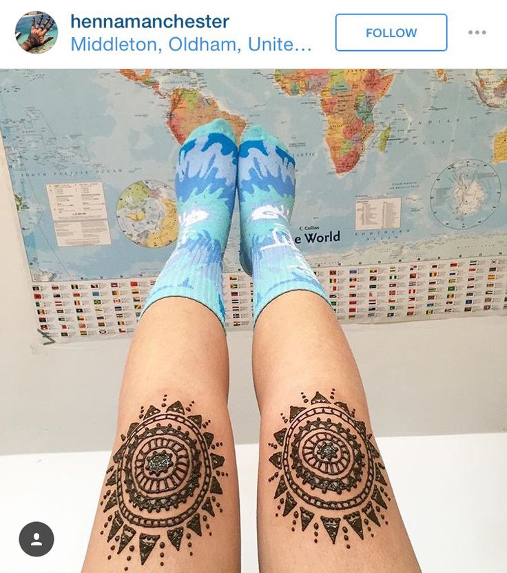 the legs and feet of a woman with henna tattoos on her body are shown in front of a world map