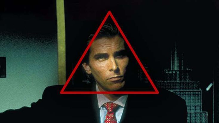 a man wearing a suit and tie with a red triangle over his head in front of him