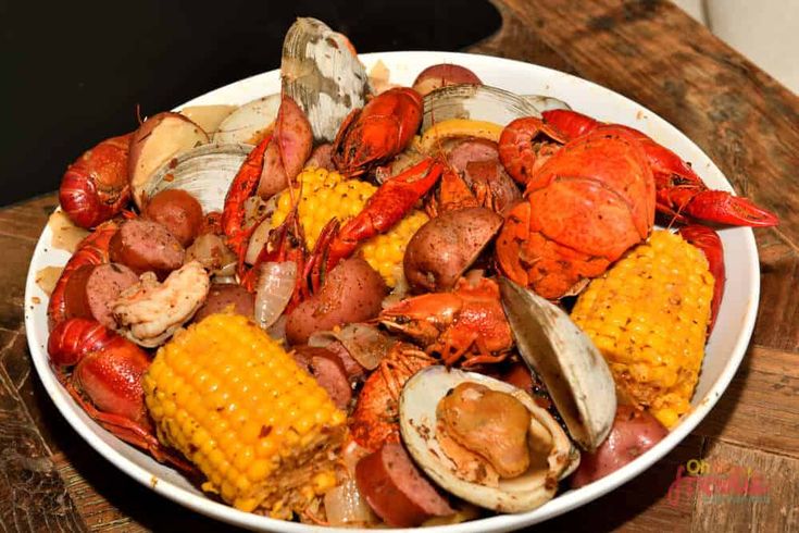 a bowl filled with seafood and corn on the cob