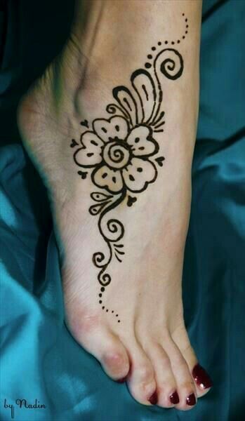 a woman's foot with a henna tattoo on the top and bottom of it