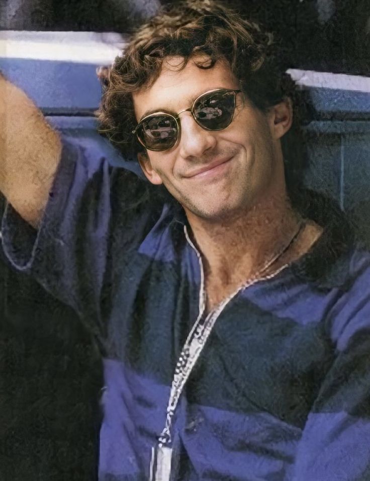 a man wearing sunglasses and smiling for the camera