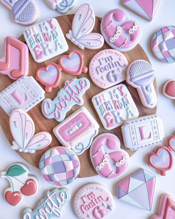 decorated cookies are arranged on a cutting board with the words happy birthday written in pink and white