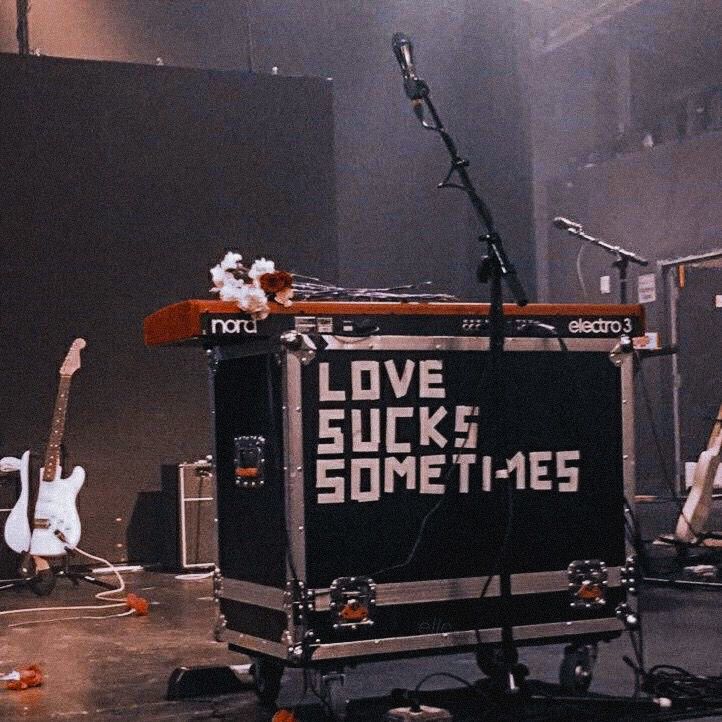 the band love sucks sometimes is performing in front of an empty stage with guitars and microphones