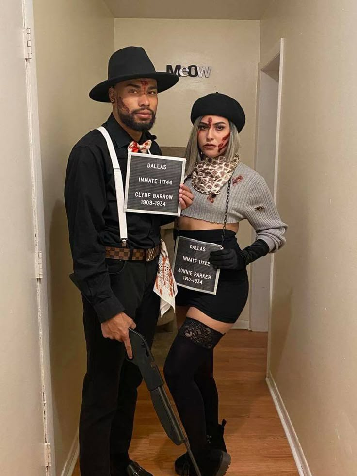 a man and woman dressed up in costumes holding signs while standing next to each other