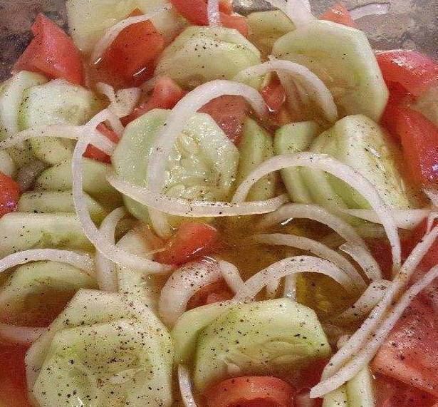 sliced tomatoes, onions and cucumbers are mixed together in a bowl to make a salad