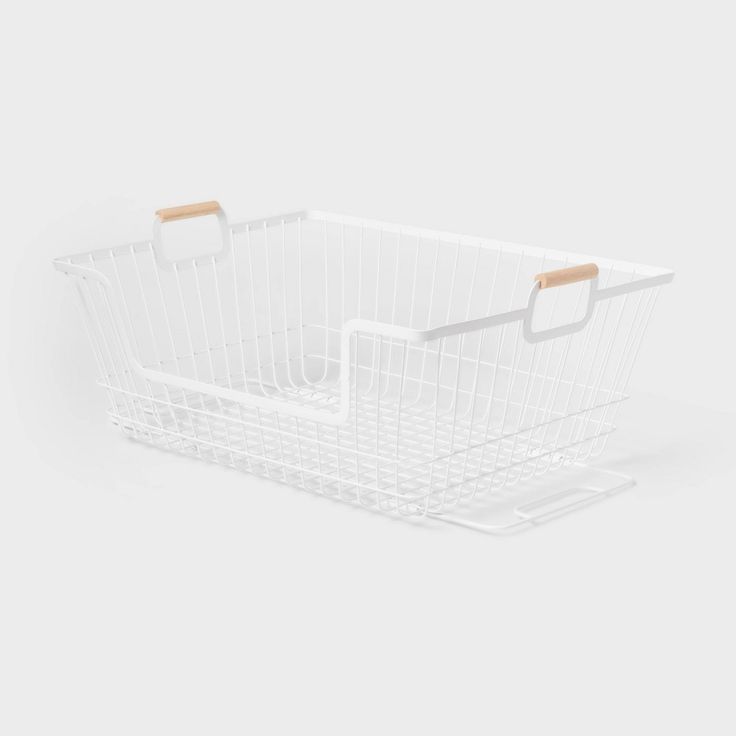 a white wire basket with wooden handles