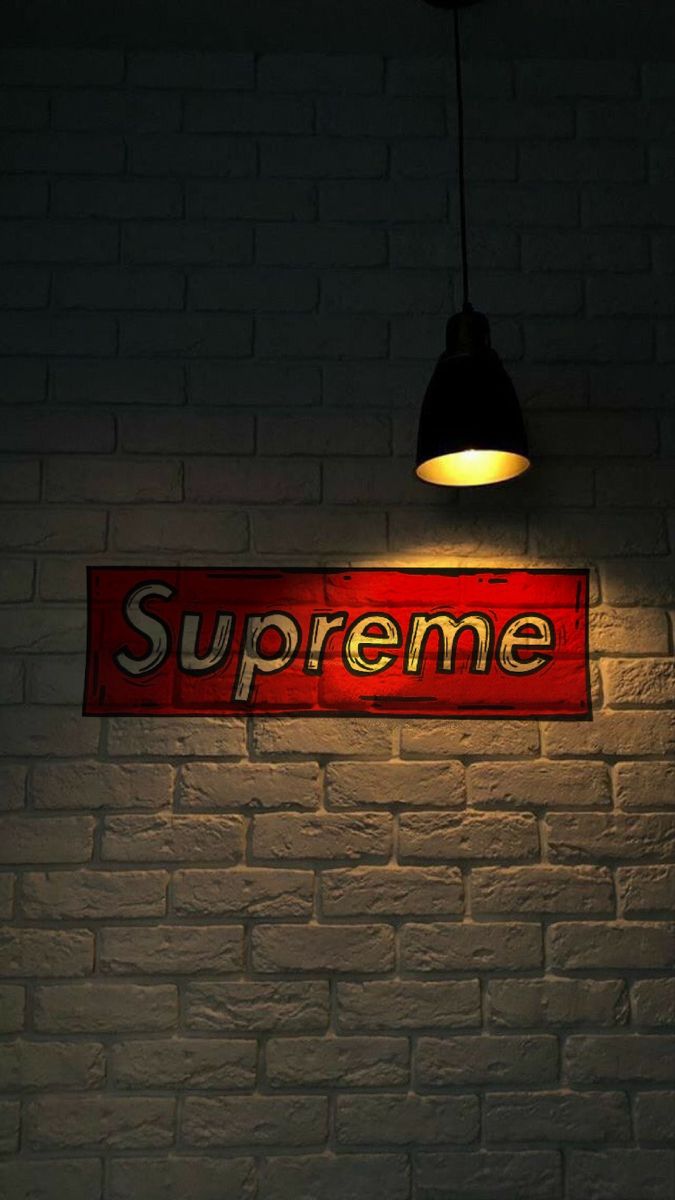 a brick wall with a sign that says supreme hanging from it's side