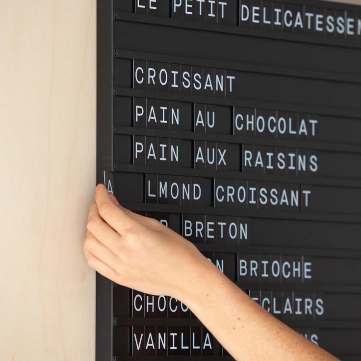 a person's hand is on the wall next to a plaque with words written in it