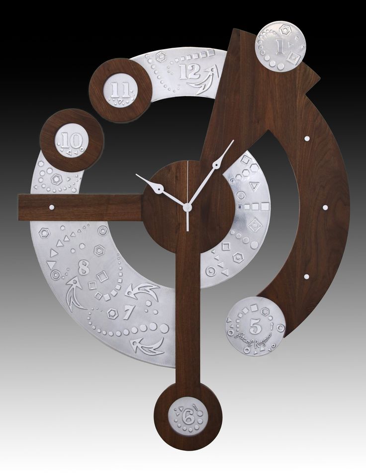 a clock made out of metal and wood with white designs on it's face