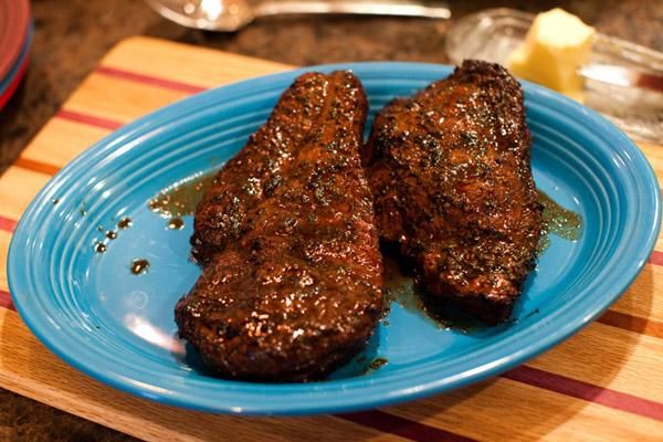 two pieces of meat sitting on top of a blue plate