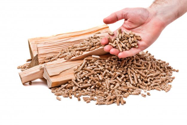 a pile of wood shavings being held by a person's hand over it