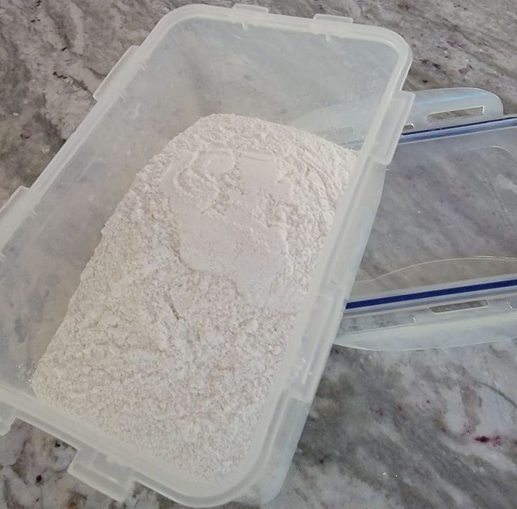 two plastic containers filled with flour sitting on top of a counter