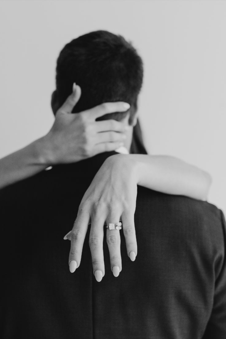 a man and woman embracing each other with their hands on the back of their shoulders