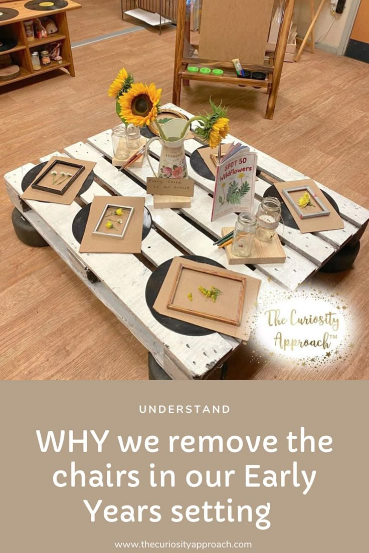 a table with pictures and flowers on it in the middle of a room that says, why we remove the chairs in our early years setting