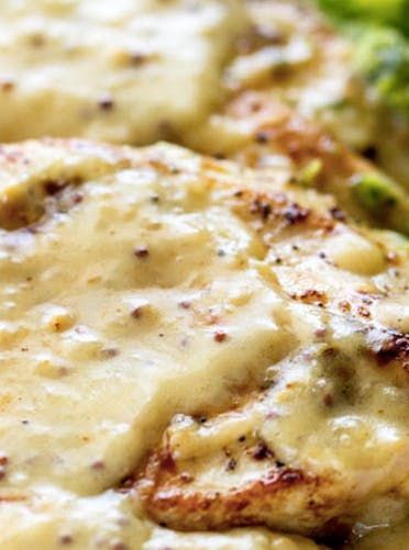 a close up of food on a plate with broccoli and sauce in it