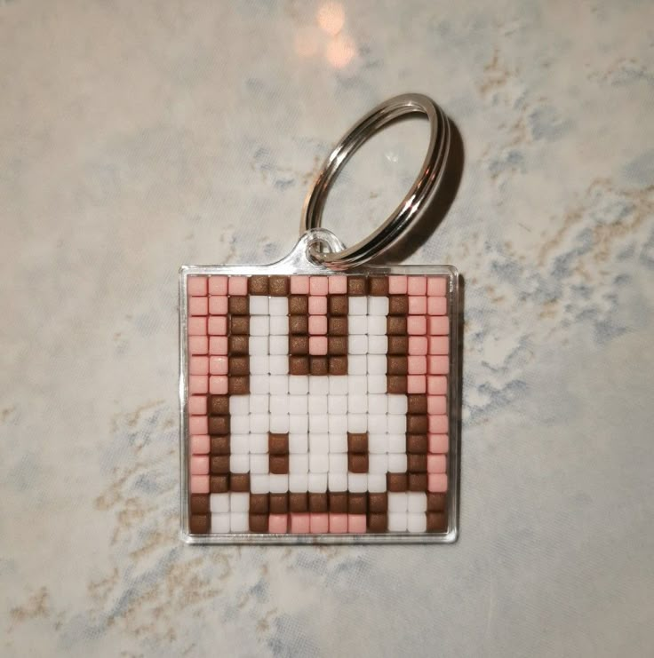 a square keychain with a pixel design on it