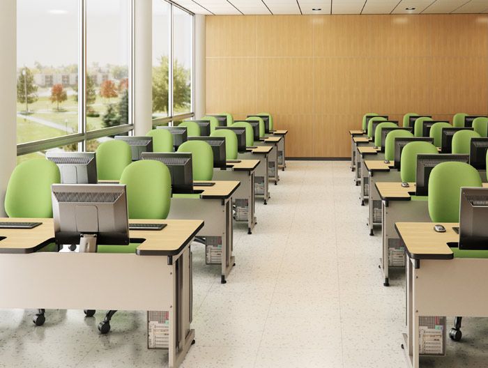 an empty classroom with desks and computers in front of large windows on the wall