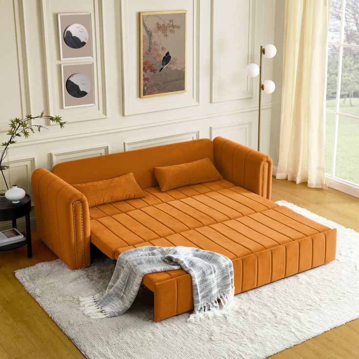 an orange couch sitting on top of a white rug