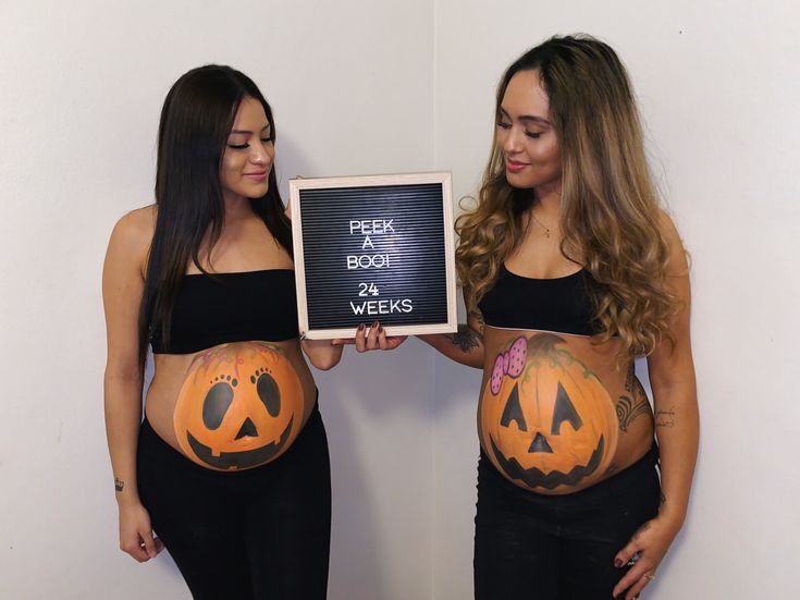 two women in halloween costumes holding up signs