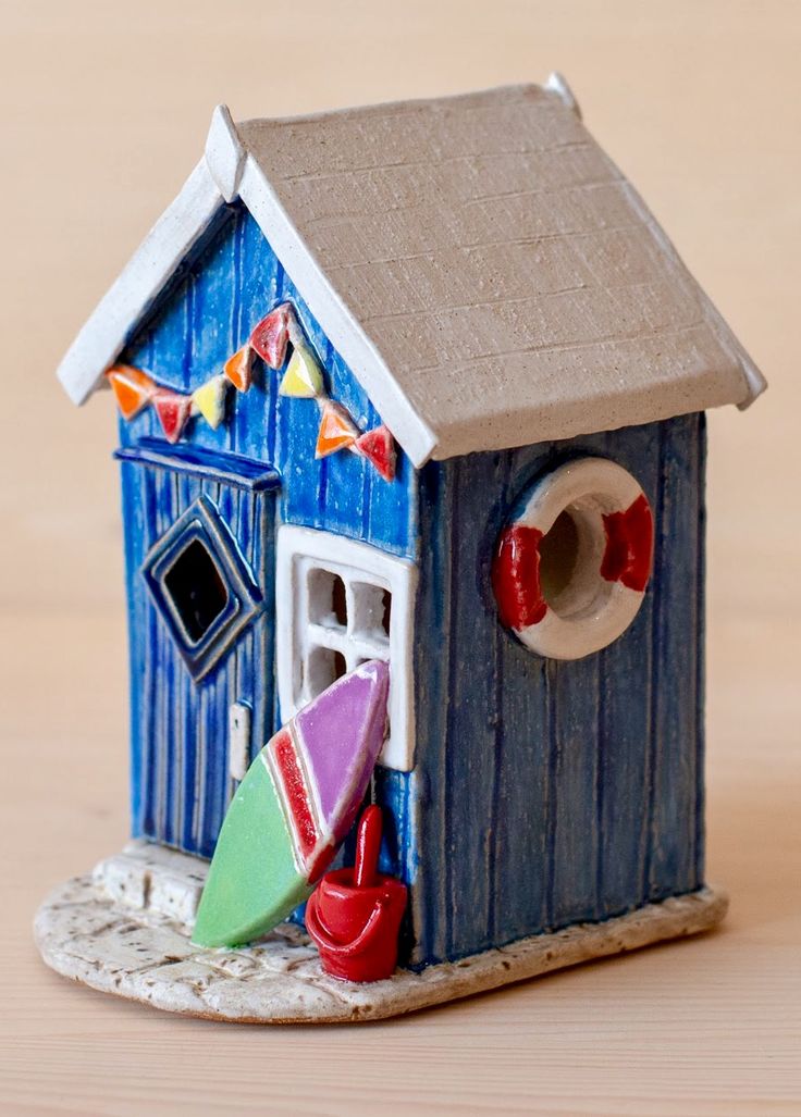 a small blue birdhouse sitting on top of a wooden table