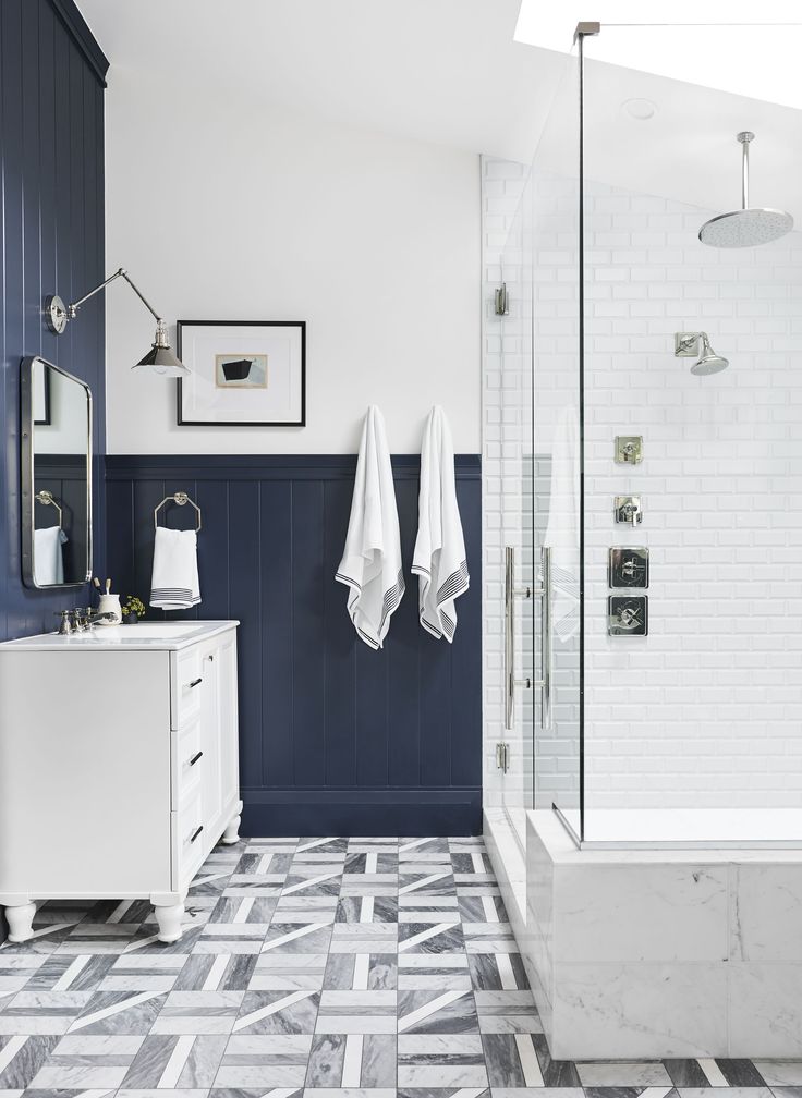 the bathroom is decorated in white and blue with black accents on the walls, along with gray tile flooring