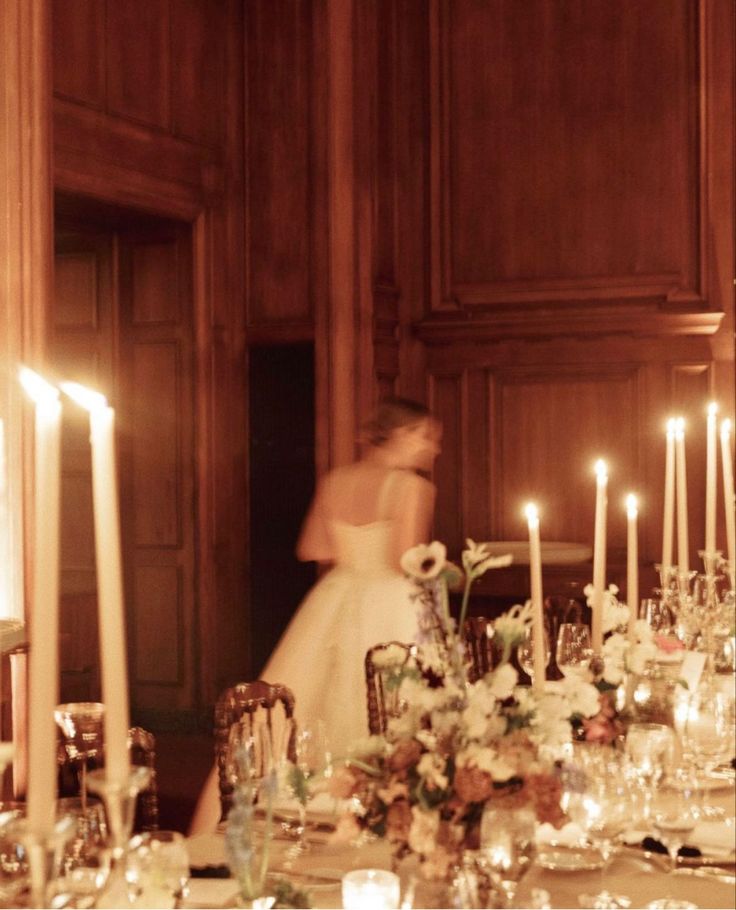 a bride and groom standing in front of a table with candles