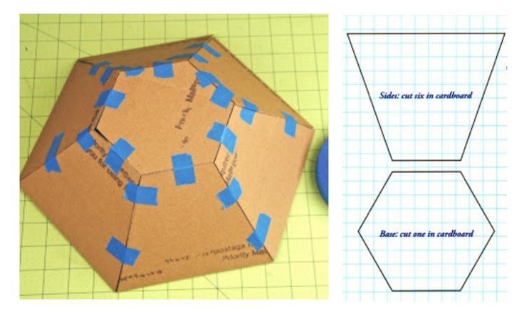 an origami hexagonal object with blue tape on it and another piece of construction paper