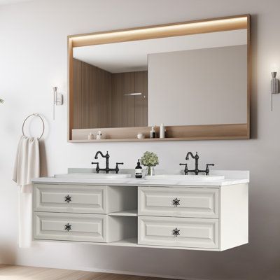 a bathroom vanity with two sinks and a large mirror above it, next to a potted plant