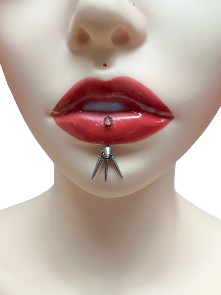 a mannequin with red lipstick and spikes on it's nose