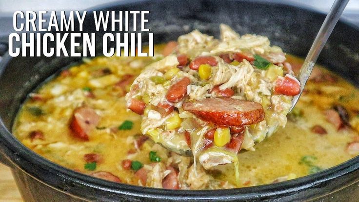 a close up of a bowl of food with a spoon in it and the words creamy white chicken chili