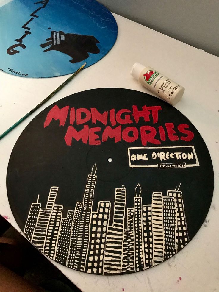 the record has been painted with red and black lettering on it, along with some other art supplies