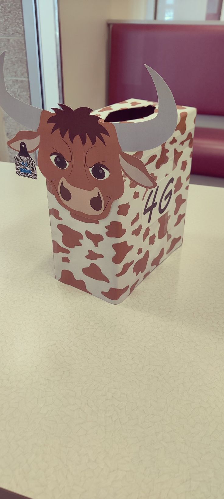 a paper bag shaped like a cow with horns on it's head sitting on a table