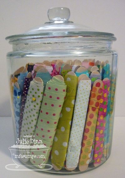 a glass jar filled with lots of different colored fabric